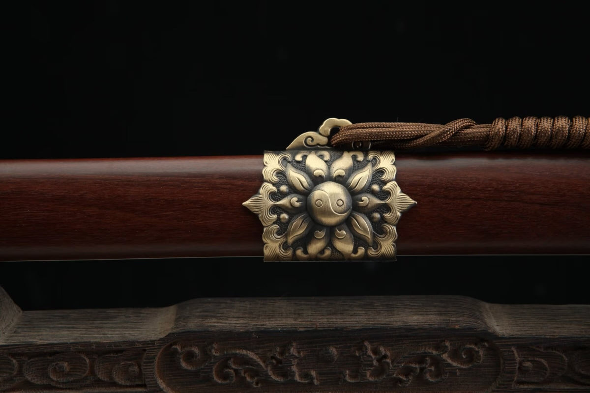 Floral brass scabbard band with a Yin-Yang motif and decorative brown cord on the Longyao Jian