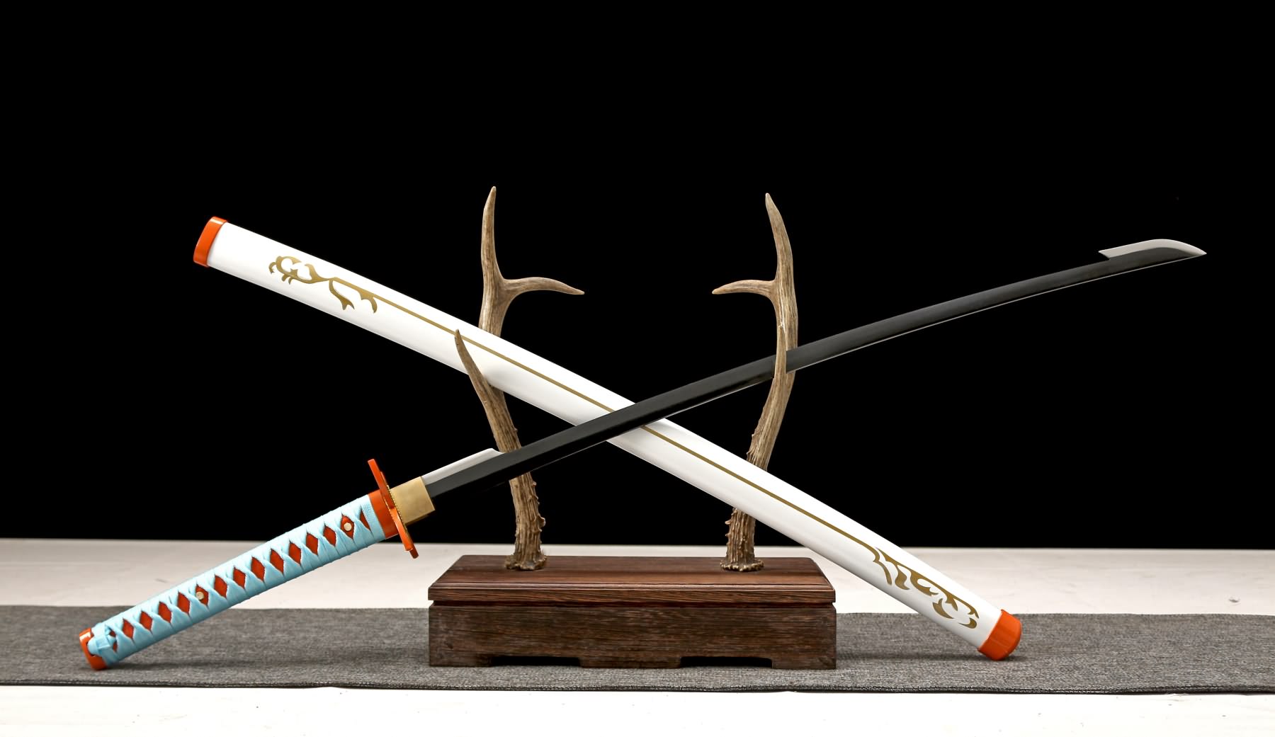 Black-blade katana displayed with white decorated scabbard