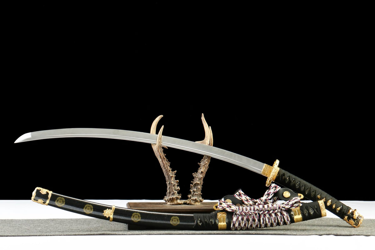 Japanese-style Tachi with polished blade and black gold-tone scabbard on an antler-style stand; stand not included