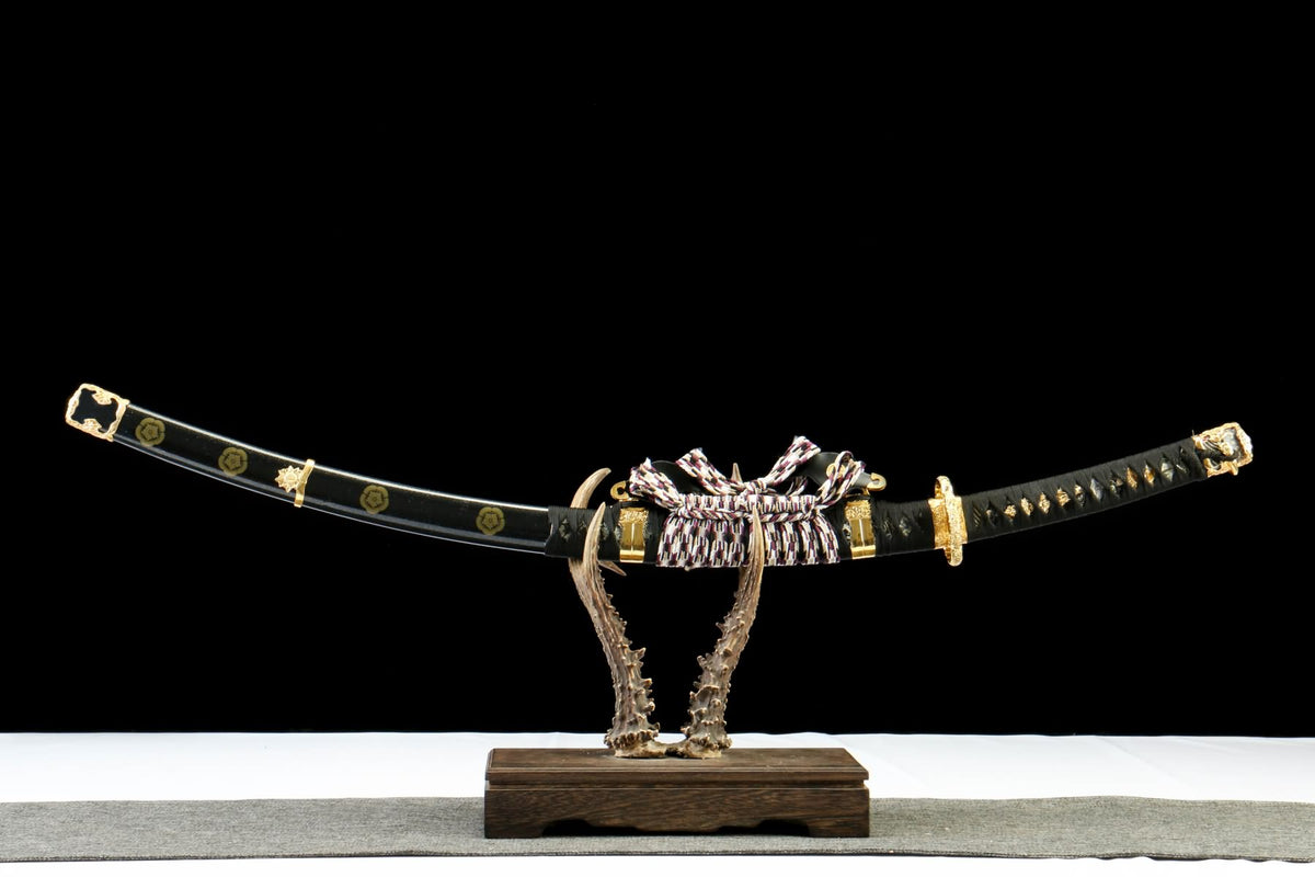 Japanese-style Tachi sheathed in a black scabbard with gold-tone fittings; display stand not included