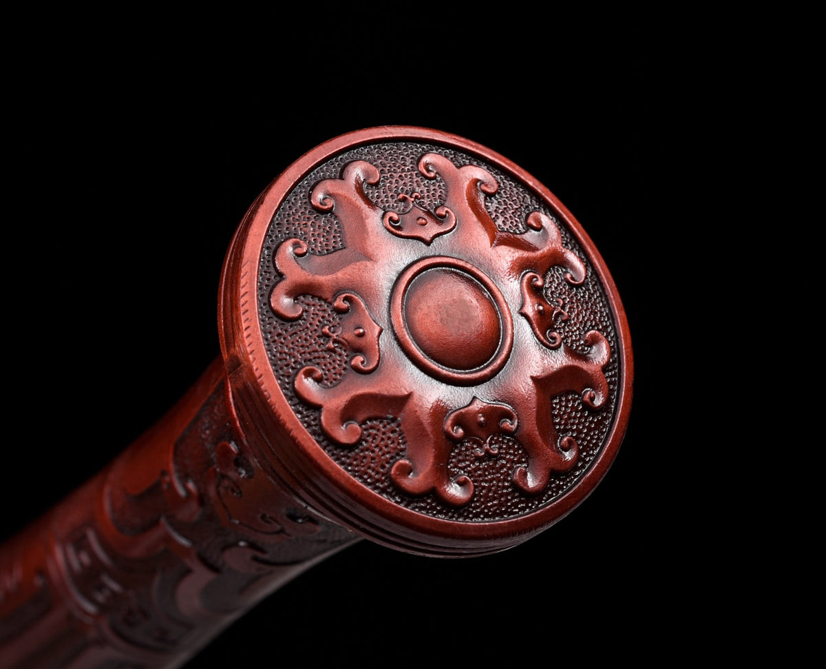 Circular alloy pommel with four beast motifs and red antique copper-tone finish
