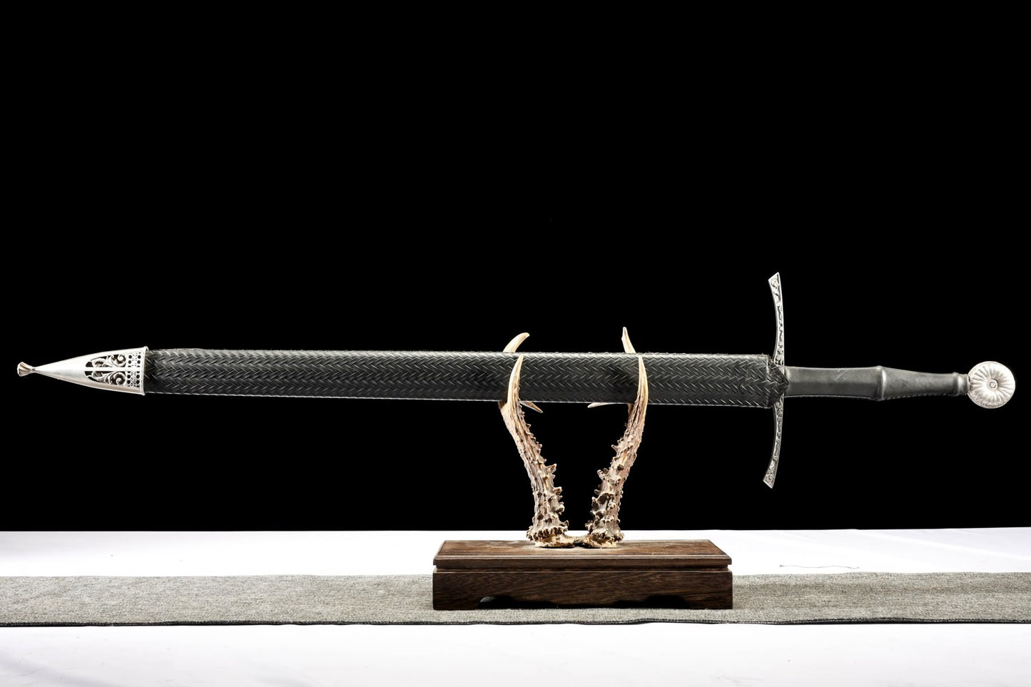 European hand-and-a-half sword fully sheathed in black scabbard