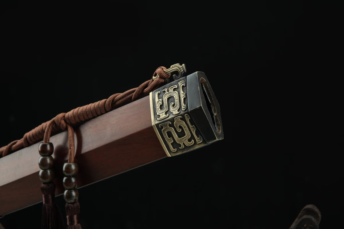 Close-up of the Hanwang Jian wooden scabbard mouth with carved brass fitting and brown cord
