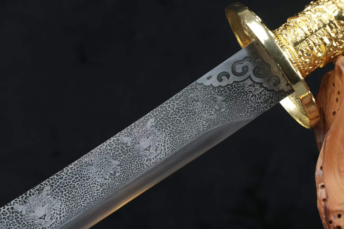 Gold-tone Kangxi Dao guard and decorative scrollwork at the base of the leopard-pattern blade
