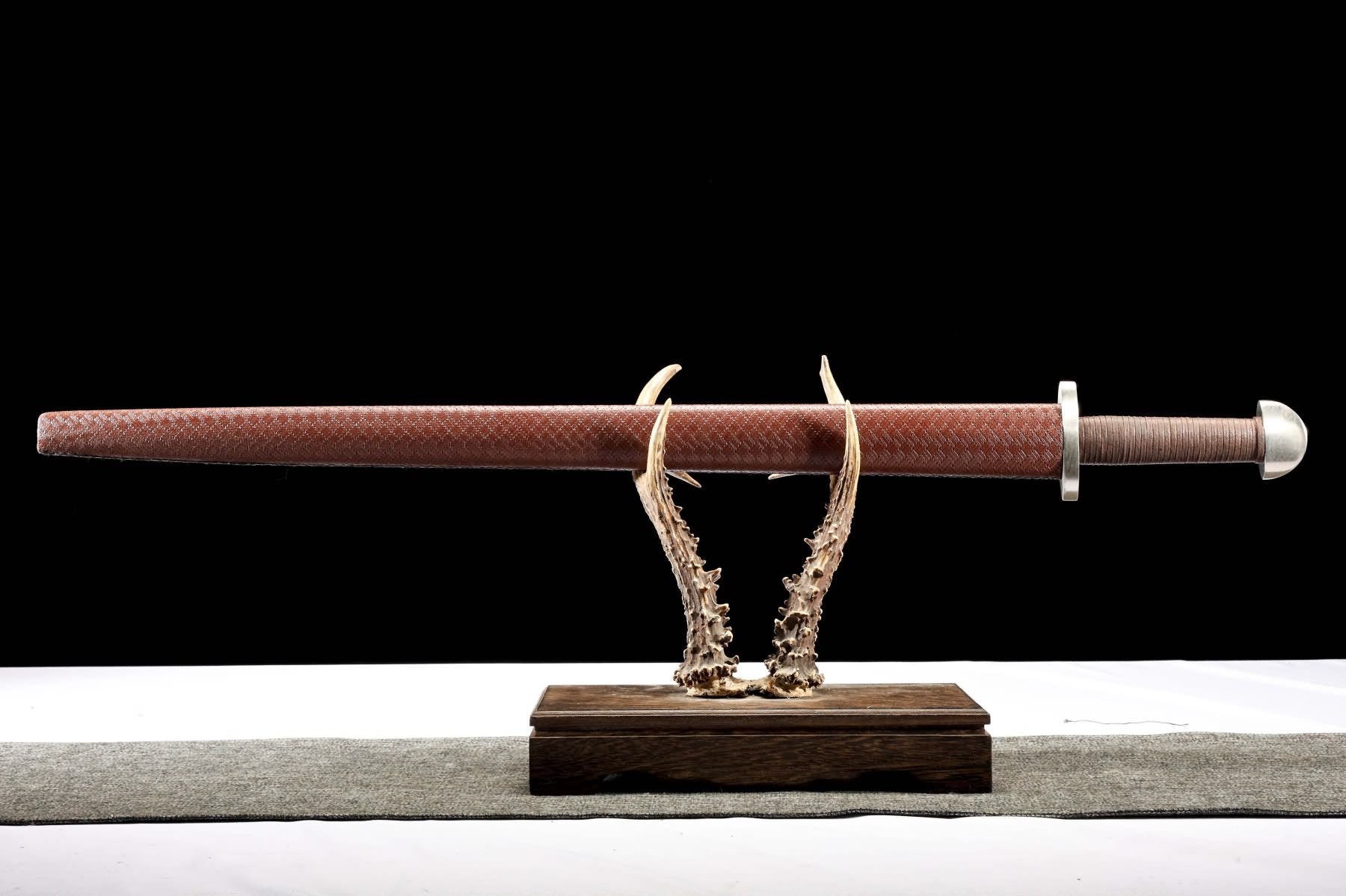Viking sword fully sheathed in textured brown scabbard