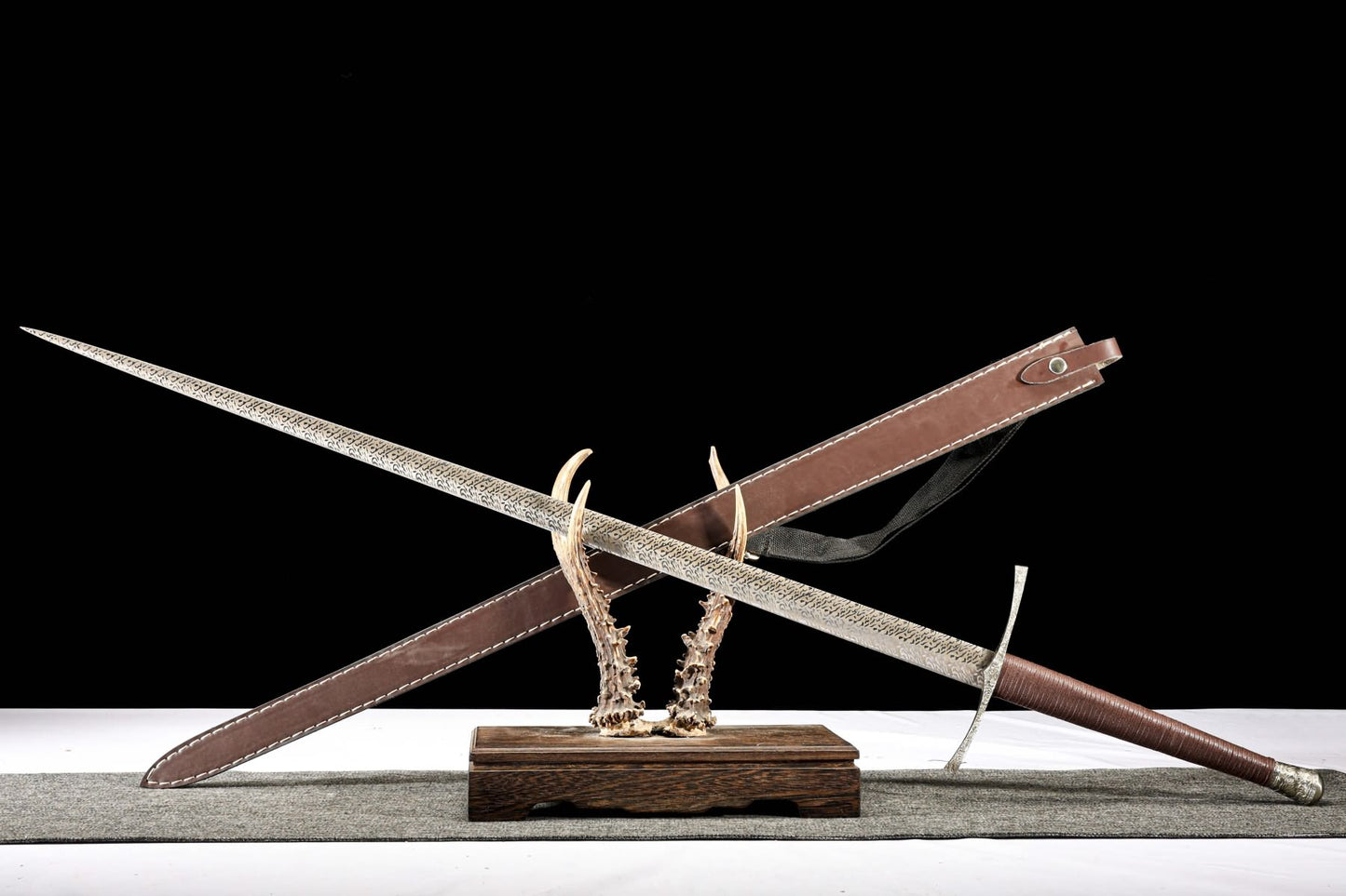 Xiangyun longsword crossed with its hand-stitched brown leather sheath